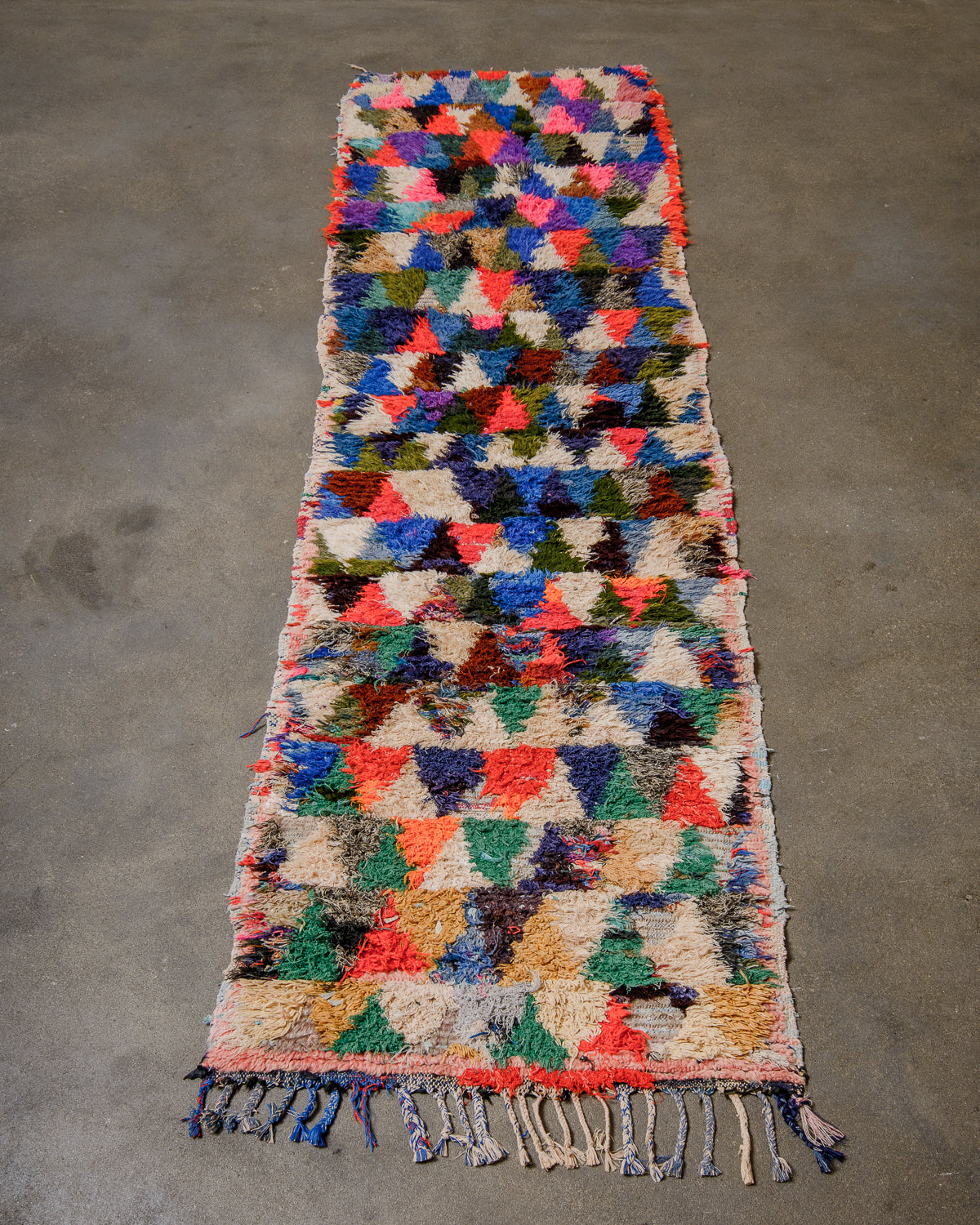 Berberlin vintage Boucherouite runner rug laying flat on concrete floor.